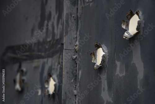 Bullet holes in metal door from iron plate