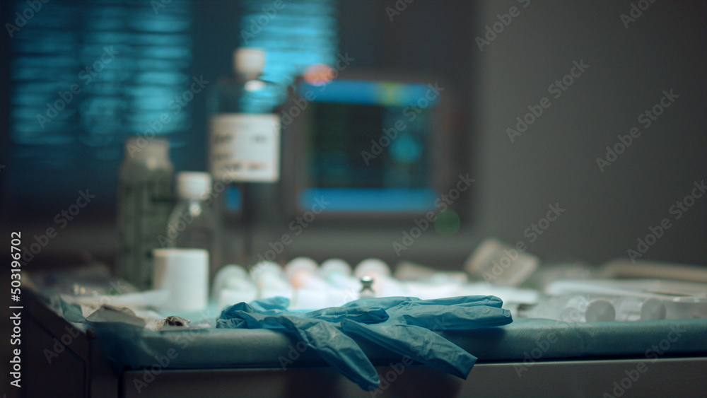 Hospital heartbeat monitor screen. Closeup medical instruments glove on table. Hospital heartbeat monitor screen. Closeup medical instruments glove on table.