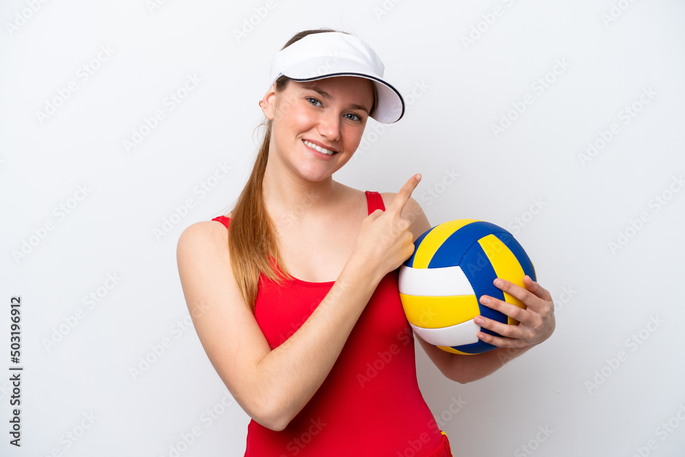 Young caucasian woman playing volleyball isolated on white background pointing to the side to present a product