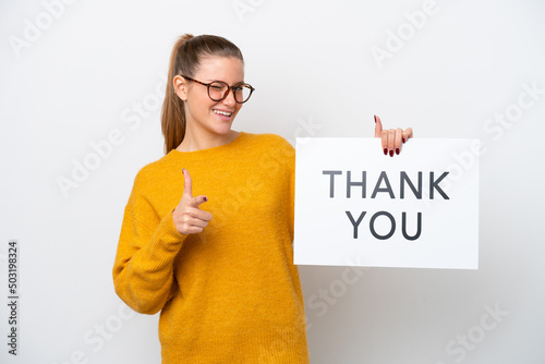Young caucasian woman isolated on white background holding a placard with text THANK YOU and pointing to the front
