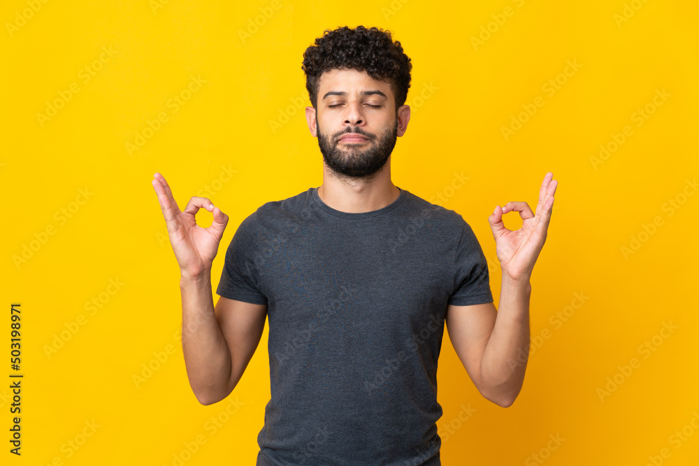 Young Moroccan man isolated on yellow background in zen pose Young Moroccan man isolated on yellow background in zen pose
