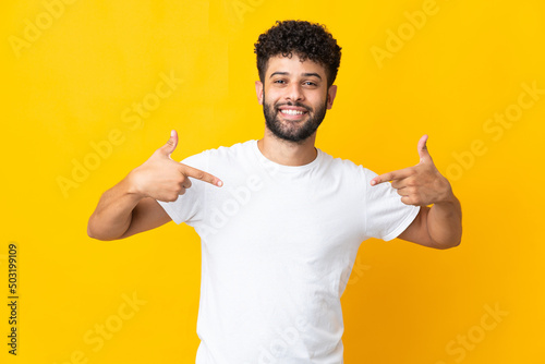 Young Moroccan man isolated on yellow background proud and self-satisfied