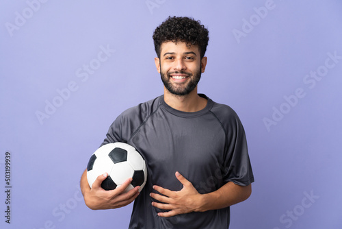 Handsome Moroccan young football player man over isolated on purple background smiling a lot