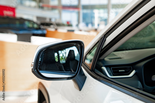 the side mirror on the white car. official dealerships and auto shops. © andrey