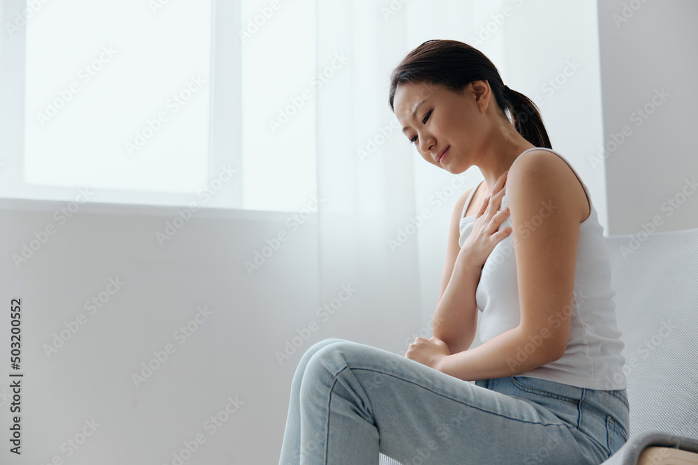 Heart attack. Suffering from pain tanned beautiful young Asian woman hold hand on chest heart crying at home interior living room. Injuries Poor health Illness concept. Cool offer Banner Heart attack. Suffering from pain tanned beautiful young Asian woman hold hand on chest heart crying at home interior living room. Injuries Poor health Illness concept. Cool offer Banner
