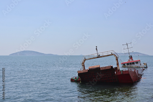 A red ship capsized in a storm off the coast of Maltepe (Istanbul) with the Princes Islands in the Sea of Marmara in the background