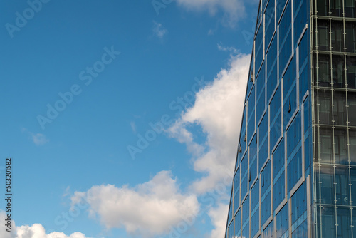 Modern office building with glass facade in downtown. Sunny sumer day