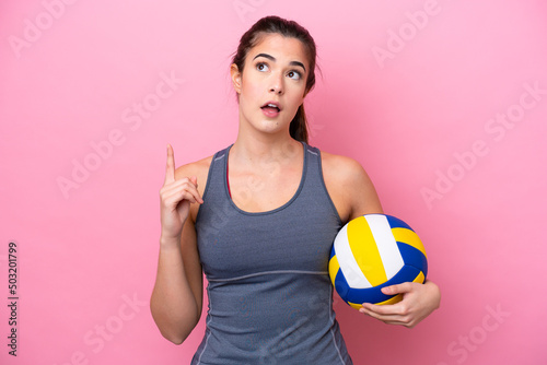 Young Brazilian woman playing volleyball isolated on pink background thinking an idea pointing the finger up