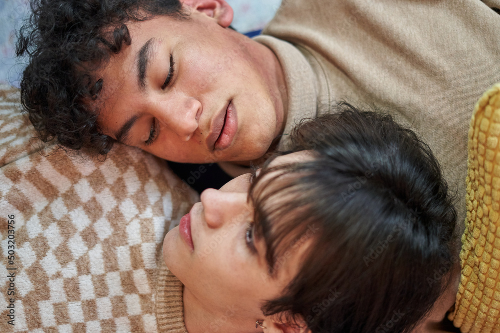 Passionate sexual gay couple in an intimate moment lying on the sofa at home