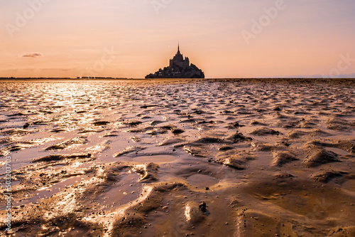 Sunset and reflection on the bay of Mont Saint Michel, Normandy, France