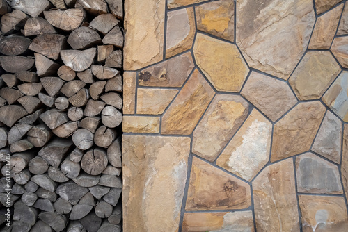 Chopped wood next to stone wall