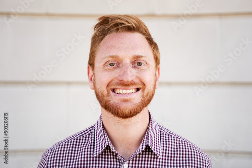 Foto Outdoor portrait of a smiling Red hair guy looking at the camera laughing with positive face and friendly look