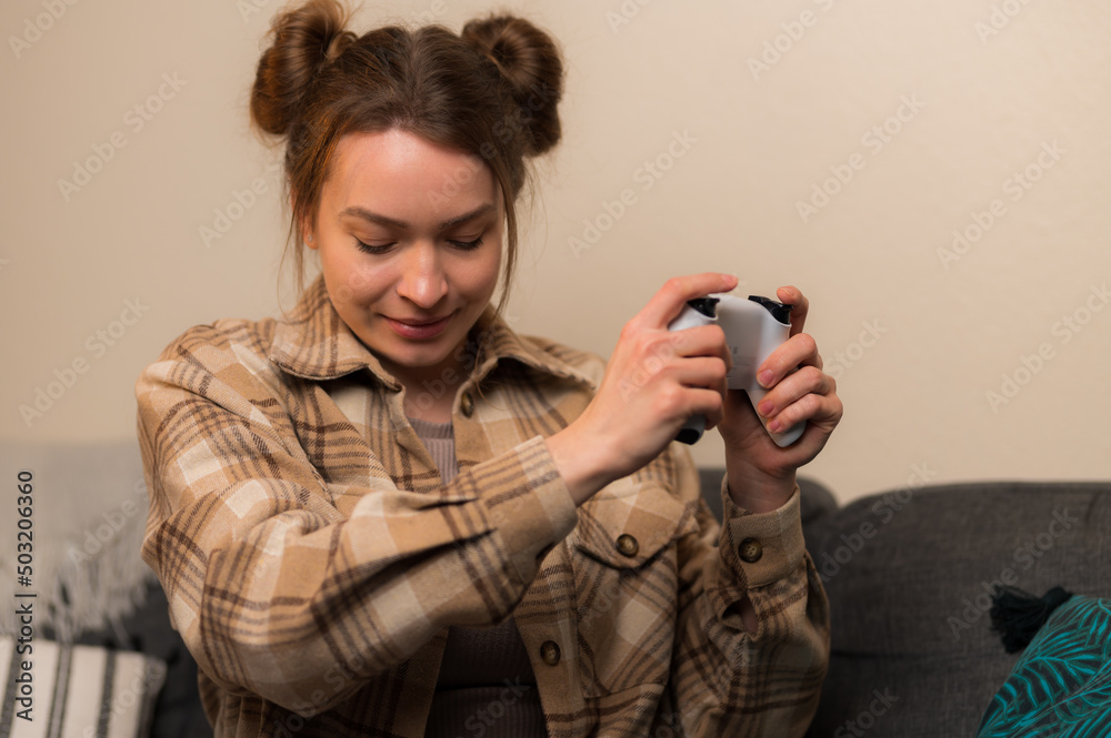 Close-up. The girl enthusiastically plays a video game. She has a joystick in her hand. Gaming, game strategy, hobby, hobby, online communication with friends, virtual reality. Close-up. The girl enthusiastically plays a video game. She has a joystick in her hand. Gaming, game strategy, hobby, hobby, online communication with friends, virtual reality.