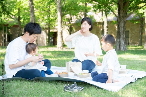 新緑の中でピクニックをする家族