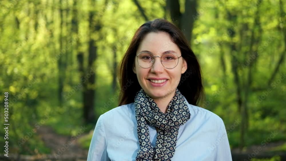 An attractive young brunette, a female ecologist-botanist with glasses, smiles and looks at the camera in the forest. Caring for nature An attractive young brunette, a female ecologist-botanist with glasses, smiles and looks at the camera in the forest. Caring for nature