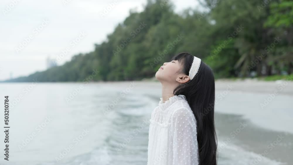 Holiday concept of 4k Resolution. Asian girl looking at the view on the beach. She was feeling refreshed with good weather. Holiday concept of 4k Resolution. Asian girl looking at the view on the beach. She was feeling refreshed with good weather.