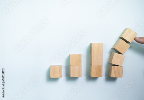 Top view finger push wooden blocks from collapse. Concept for protecting business.