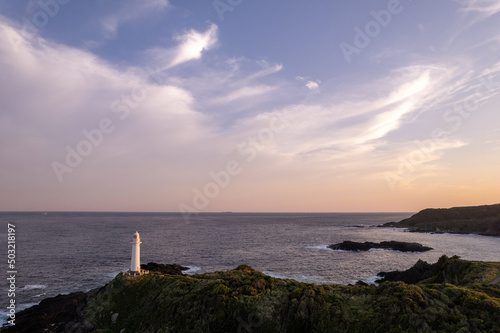 夕暮れの灯台と岬の風景