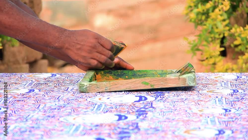 Close up of hand pressing squeegee on a wooden screen printing vox Close up of hand pressing squeegee on a wooden screen printing vox