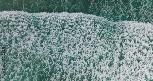 Top down view of waves breaking at shore. Aerial of seascape. Global seawater rising concept