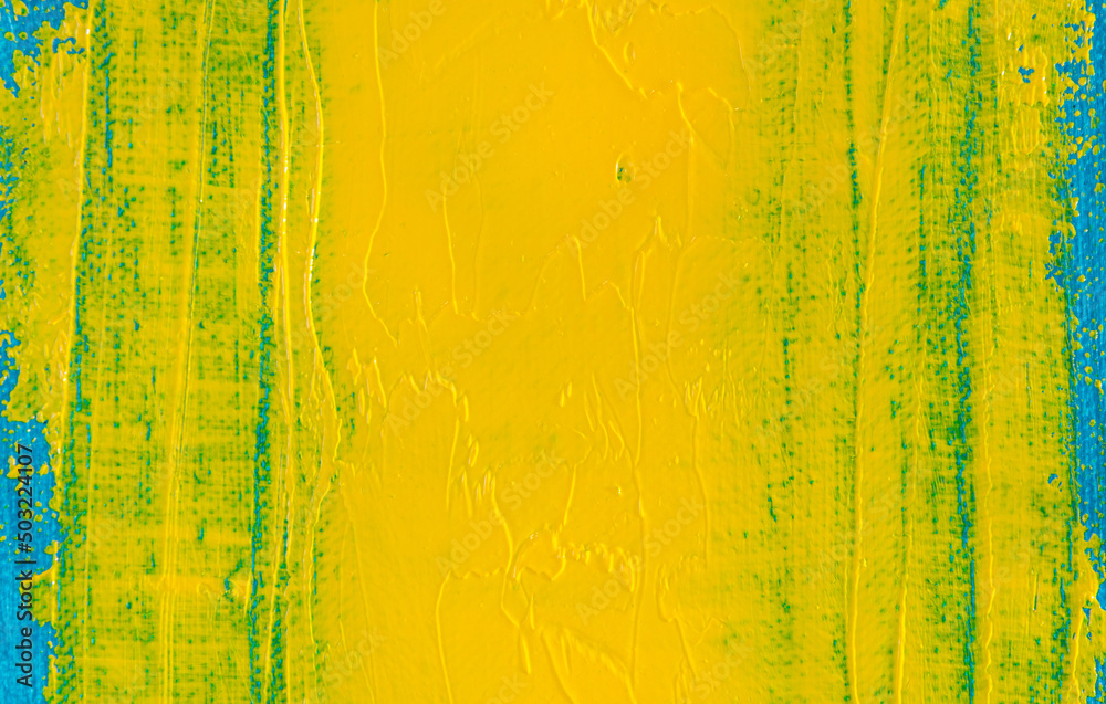 Naklejka premium abstract bright colored background: a smeared flat wide spot of yellow paint on a blue fabric close up