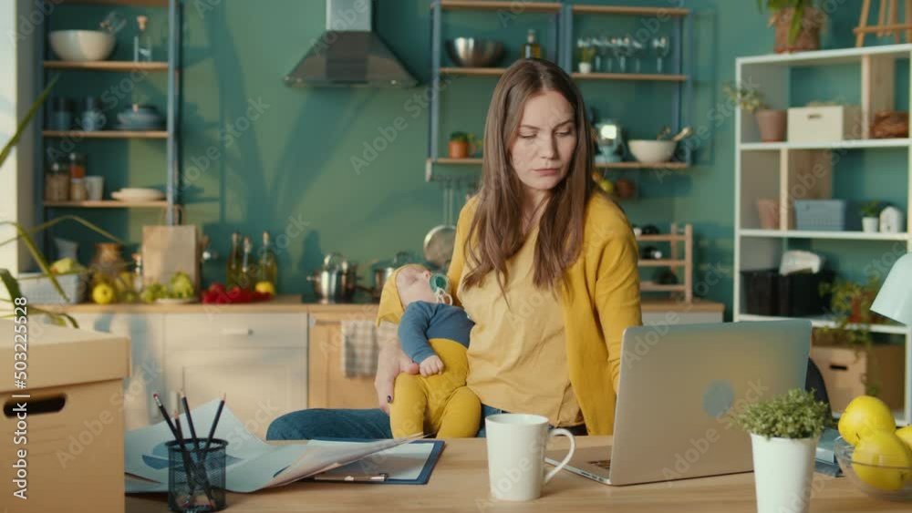 Mother Freelance Worker With Child at Workplace.Stressed Business Woman Working From Home on Laptop Looking Worried, Tired and Overwhelmed.Upset Woman Have Headache. Mother Freelance Worker With Child at Workplace.Stressed Business Woman Working From Home on Laptop Looking Worried, Tired and Overwhelmed.Upset Woman Have Headache.