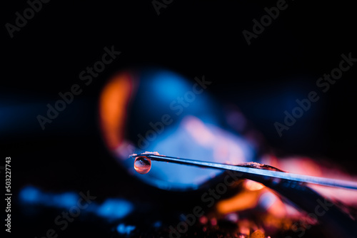Tip of a syringe needle with a drop of heroin cooked in it. Concept of drug addiction.