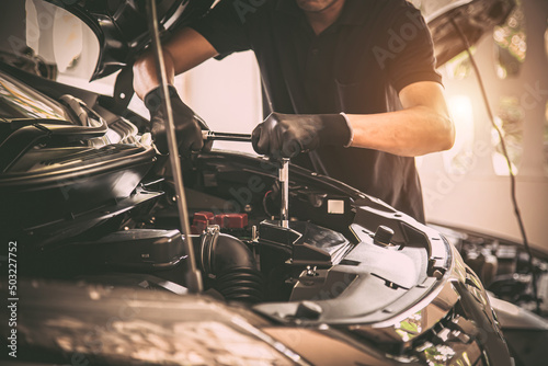 Close-up hand auto mechanic using the wrench to repairing car engine problem. Concepts of check and fix car and maintenance servicing.