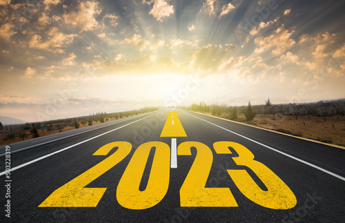New year concept. Anniversary time from 2022 to 2023. Text 2023 written on the road in the middle of asphalt road at sunrise.Concept of planning and business strategy.