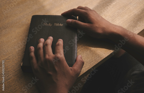Fotografie, Obraz Human hands praying for God's blessings on a wooden table for a better life