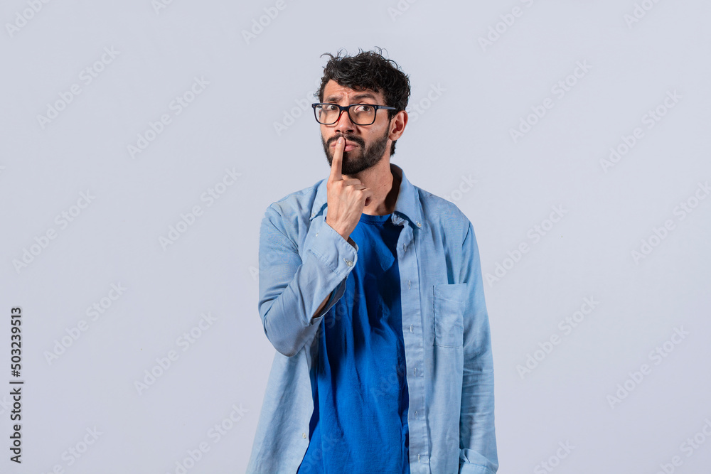 pensive young man with his finger on his lips on an isolated background, a pensive guy with a finger on his lips, pensive man on an isolated background pensive young man with his finger on his lips on an isolated background, a pensive guy with a finger on his lips, pensive man on an isolated background