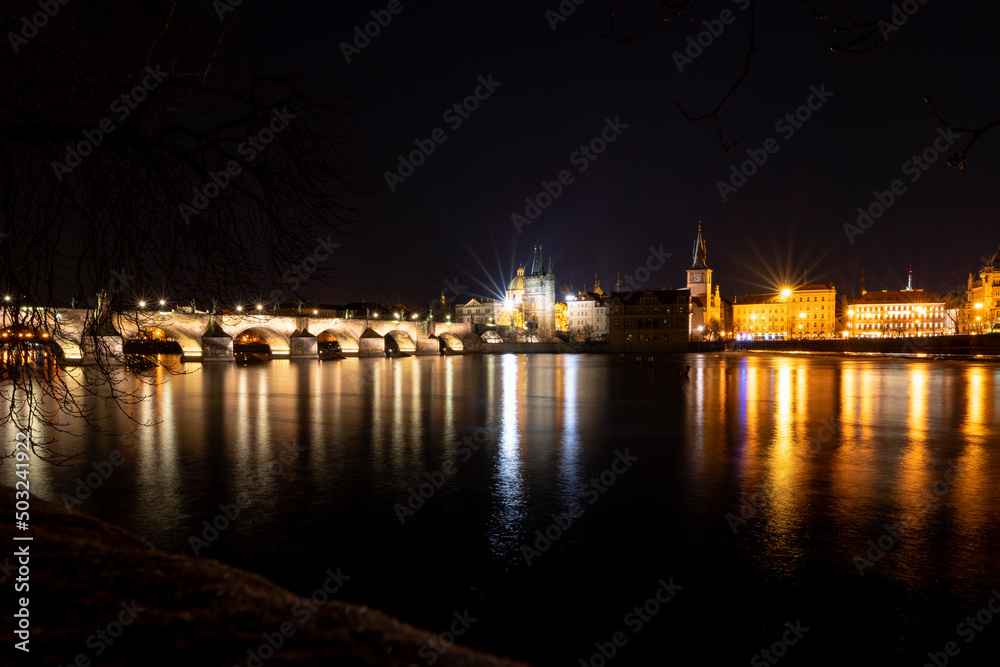 View of the Vltava River and the bridges shined with the summer sunset sun. Prague - Historic Charles bridge, Czech Republic. At night.