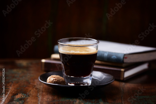 Coffee in glass cup on dark wooden background. Copy space.