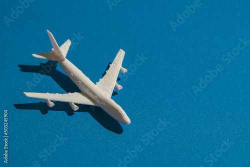 A miniature airplane isolated on blue background, Travel or traffic background, Nobody	
