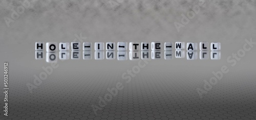 hole in the wall word or concept represented by black and white letter cubes on a grey horizon background stretching to infinity