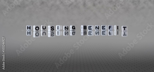 housing benefit word or concept represented by black and white letter cubes on a grey horizon background stretching to infinity