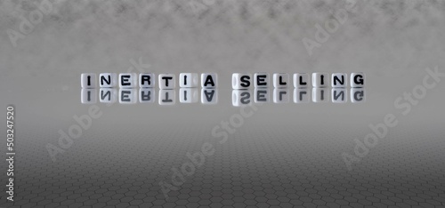Konstfotografi inertia selling word or concept represented by black and white letter cubes on a