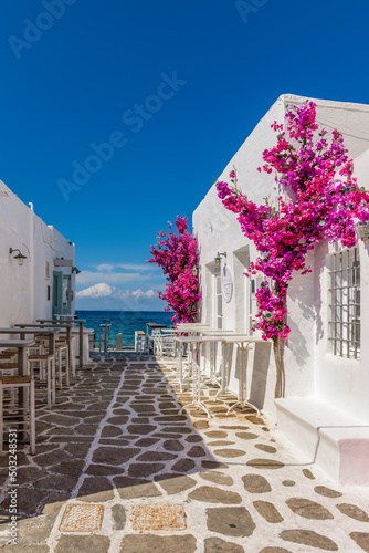 Traditional Cycladitic view with an exterior of a bar besides the sea during summer time in Naousa Paros island, Greece