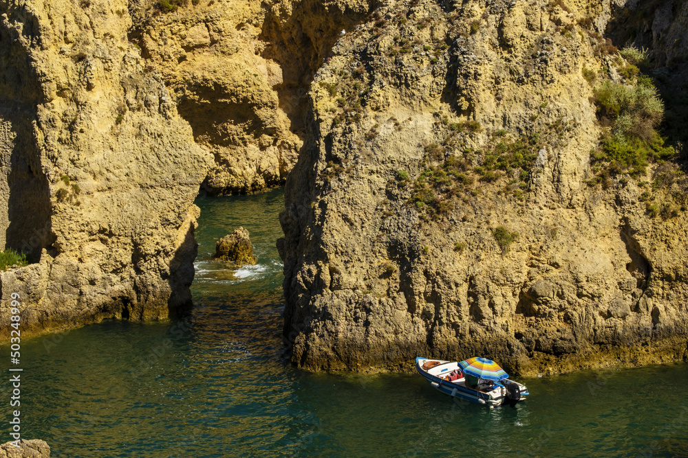Panoramic view with Cliff, rocks and tourist boat on sea at Ponta da Piedade near Lagos, Algarve, Portugal