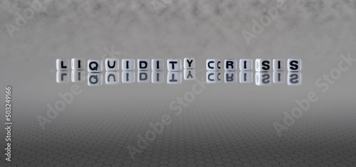 liquidity crisis word or concept represented by black and white letter cubes on a grey horizon background stretching to infinity
