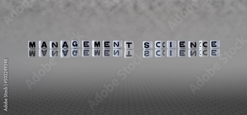 management science word or concept represented by black and white letter cubes on a grey horizon background stretching to infinity