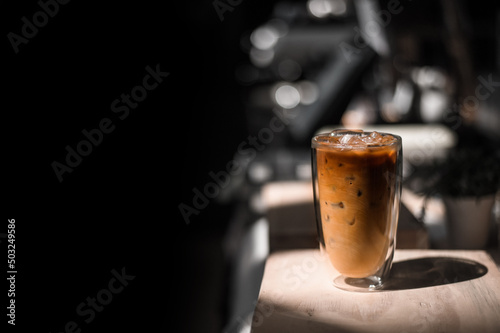 Close-up glass of iced coffee with milk on the table
