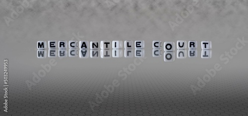 mercantile court word or concept represented by black and white letter cubes on a grey horizon background stretching to infinity