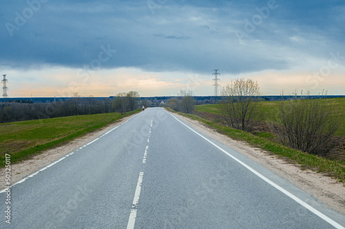 road in the countryside background landscape with trees and big green field and blue sky and white clouds