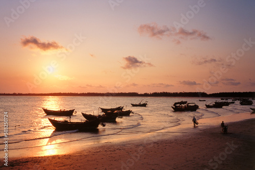 Guangdong maoming romantic coast with some boats under sunset photo