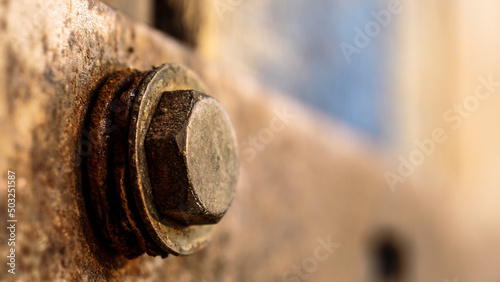 Macro photo of a detail on a blue door, with a rusty bolt