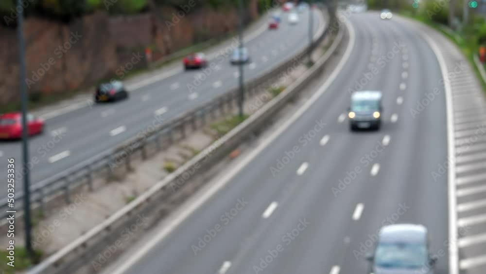 Blurred view of traffic on curved motorway by the rock in the United Kingdom, high angle, defocused. Blurred view of traffic on curved motorway by the rock in the United Kingdom, high angle, defocused.