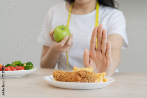 Diet  Dieting asian young woman hand in push out  deny fried chicken  french fried and choose green apple  vegetables salad  eat food for good healthy  health when hungry. Female weight loss people.