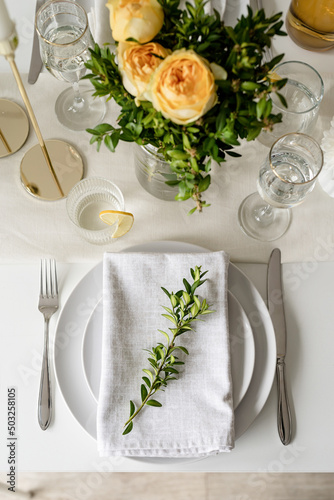 The wedding table setting, top view. Wedding teble decoration with beige roses and boxwood