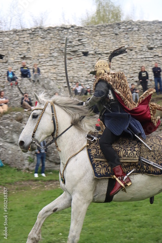 Принти на полотні a hussar on a rotten mare in a leopard cape and chain mail gallops with a sword